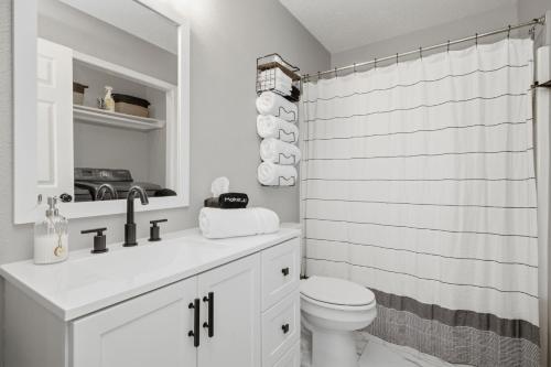 a white bathroom with a toilet and a shower at Bed n Bikefast in Bentonville