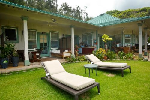 a house with two lawn chairs and a table at Iao Valley Inn in Wailuku