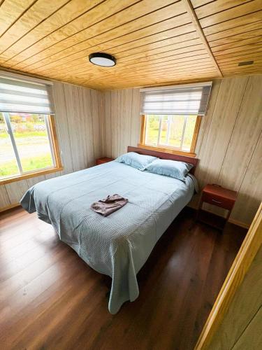 a bedroom with a bed in a wooden room at Cabañas Costanera Puyuhuapi in Puerto Puyuhuapi