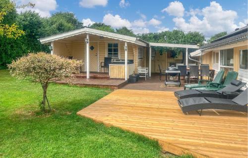 a backyard with a wooden deck and a house at 4 Bedroom Cozy Home In Stege in Stege