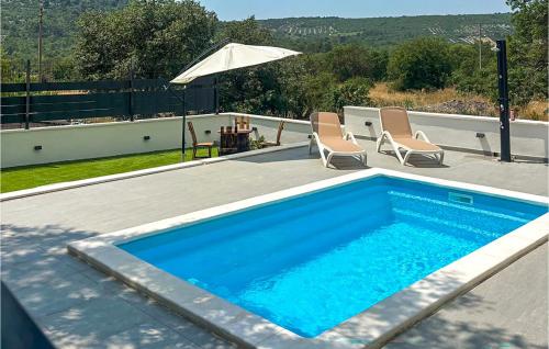 a swimming pool with two chairs and an umbrella at Gorgeous Home In Primosten in Primošten