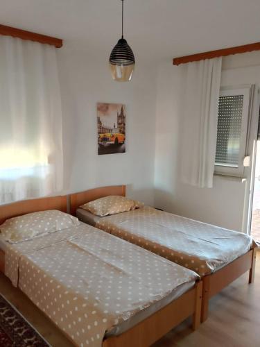 two twin beds in a room with a window at Casa SOLE in Bihać