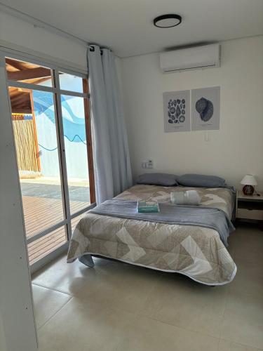 a bedroom with a bed and a sliding glass door at Casa Brisa - Las Caracolas in Rio Grande