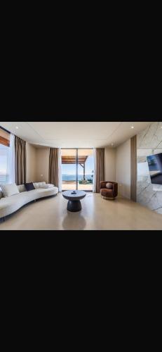 a bedroom with a bed and a table in a room at Panorama Villa Infinity Pool in Shëngjin