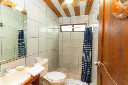 a bathroom with a toilet and a sink and a mirror at Almendro house playa Panamá in Playa Panama