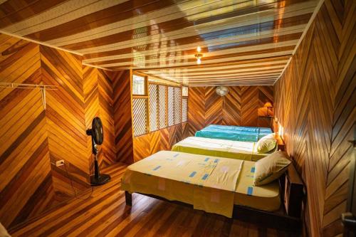 a bedroom with a bed in a room with wooden walls at Almendro house playa Panamá in Playa Panama