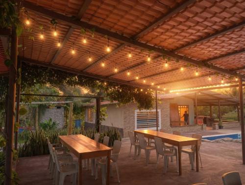 a patio with tables and chairs under a pergola with lights at Guanawanna in Loreto