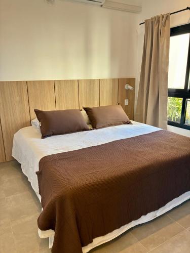 a large bed in a bedroom with a window at Plaza Suites Cafayate in Cafayate