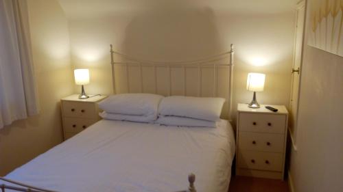 a bedroom with a bed with pillows and two lamps at Feochan View in Oban