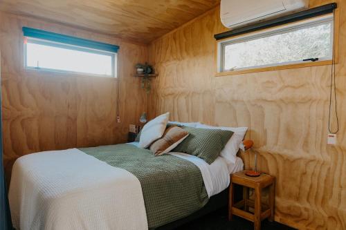 a bedroom with a bed in a small room at Warm & Cosy Studio Cabin in Hamilton