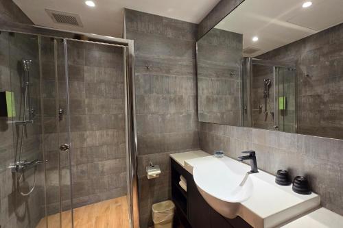 a bathroom with a sink and a shower at Hotel R14 in Kaohsiung