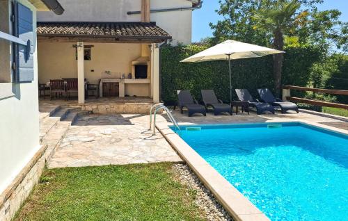 a swimming pool with an umbrella next to a house at Lukas-Gologorica in Gologorica