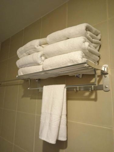 a pile of towels on a towel rack in a bathroom at Sweet Escape Executive Studio at One Regis in Bacolod