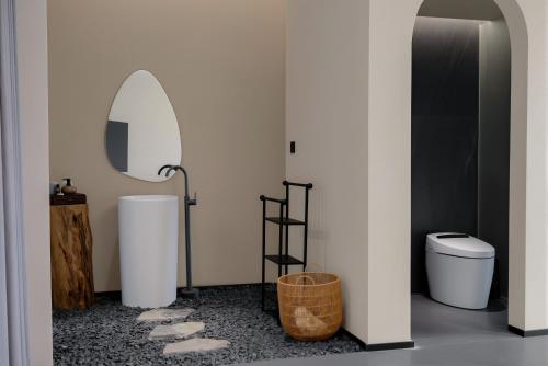 a bathroom with a toilet and a mirror at Chyanmu Hidden Village Retreat Near The Grand Canyon of Zhangjiajie and Yellow Dragon Cave With Local Culture Village Life Breakfast Quiet Wellness Escape for Urban Travelers Seeking Privacy and Peace in Zhangjiajie