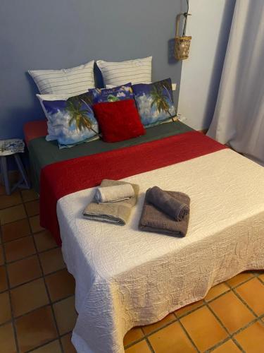 a bedroom with a bed with towels on it at Évasion Tropicale à Tartane in Tartane