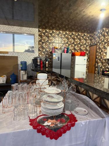 a table with plates and wine glasses on it at Caribe de Alter - Hotel & Pousada in Santarém
