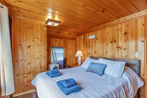 a bedroom with a bed with blue towels on it at Riverside Cabin with Private Fishing Access! in Pulaski