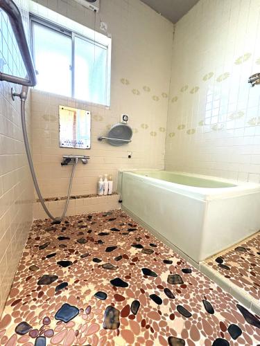 a bathroom with a shower and a bath tub at 灯ゲストハウス石巻 in Ishinomaki