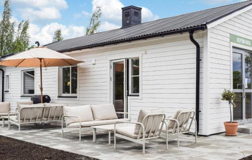 a group of chairs and an umbrella on a patio at Beautiful Home In Ystad in Ystad