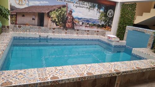 a swimming pool in a house with a tiled floor and a swimming pool at Balneario del Inca in Los Baños del Inca
