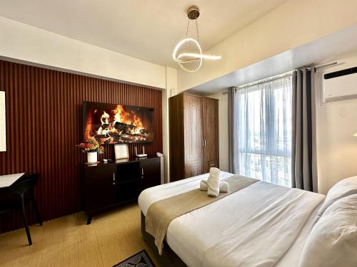 a hotel room with a large bed and a desk at City View Studio Unit at Centrio Tower beside Ayala Mall in Cagayan de Oro