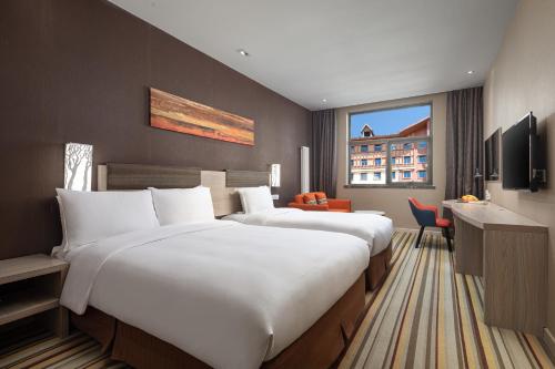 a hotel room with two beds and a desk at Holiday Inn Express Changbaishan by IHG in Fusong