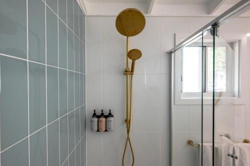 a bathroom with a shower with blue tiles at Great Keppel Island Hideaway in Great Keppel