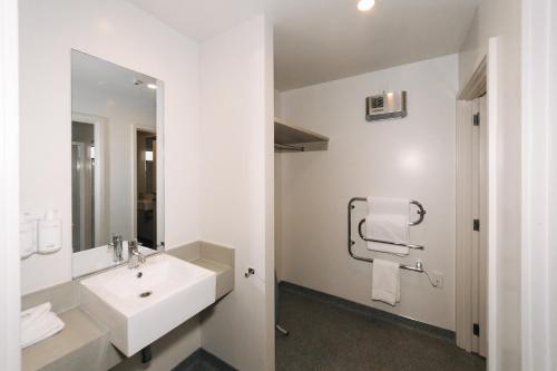 a white bathroom with a sink and a mirror at Northstar Motel in Oamaru