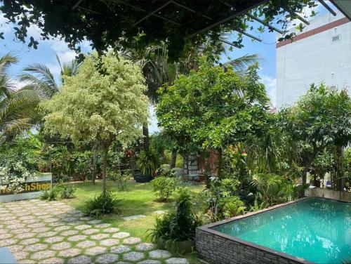 a garden with a swimming pool and trees at Một Phòng Trong Villa View Sân Vườn, Hồ Bơi in Ấp Phú Khương