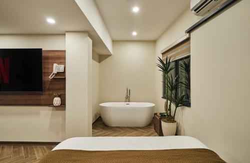 a bathroom with a bath tub and a sink at Centoria Hotel By Urban B in Ho Chi Minh City
