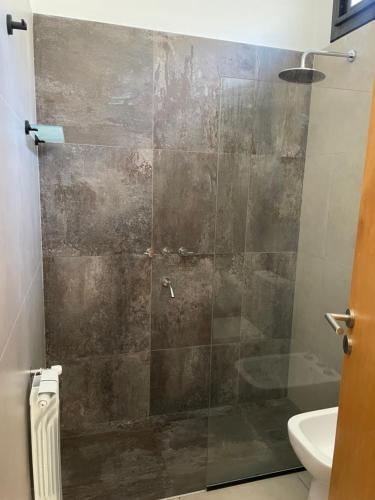 a bathroom with a glass shower with a toilet at Terruar Wine in Ciudad Lujan de Cuyo