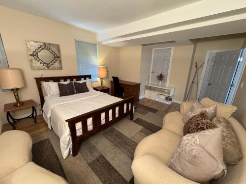 a bedroom with a bed and two couches at Dream House -Water Lily in Horseshoe Bay