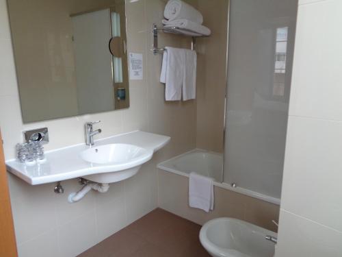 a bathroom with a sink and a mirror and a tub at Hotel Villa De Betanzos in Betanzos