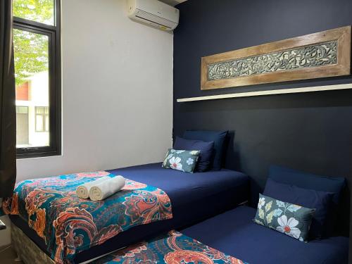 two beds in a room with blue walls at The Valley Guesthouse in Malang