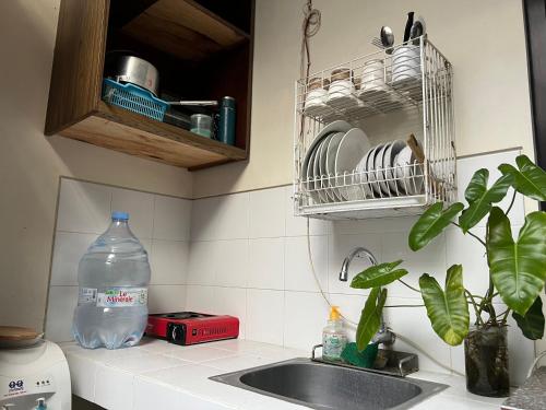 a kitchen counter with a sink and a bottle of water at The Valley Guesthouse in Malang