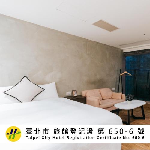 a hotel room with a bed and a chair at Meworld Hotel - Daan in Taipei