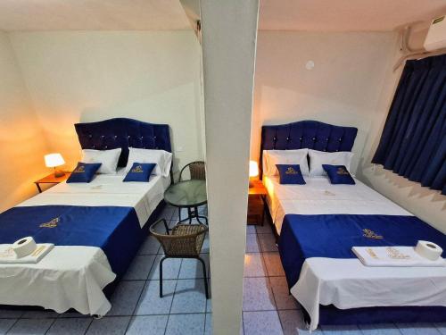 a hotel room with two beds and a table at Hotel Delcor Suite in Piura