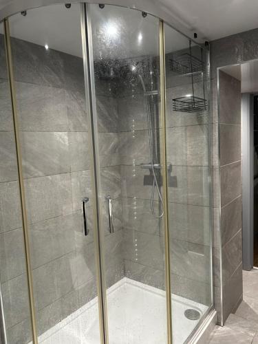 a shower with a glass door in a bathroom at Haven Home 3 bedrooms near Sunderland City Centre Downstairs Shower with Toilet and Upstairs Bath with Toilet TV in each room in Sunderland