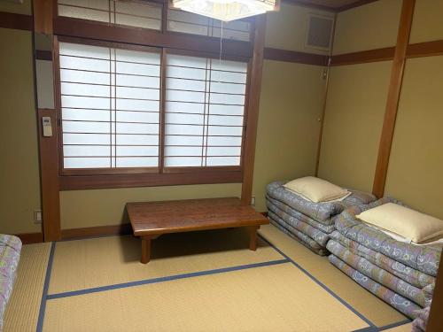 a living room with a table and a window at GATE80香住 無人宿 完全セルフ 予約メッセージ欄確認要す スマートロック 暗証番号チェックイン 素泊まり専門 アメニティ持参で格安滞在 セコム24h監視 駐車場10台 in Kami