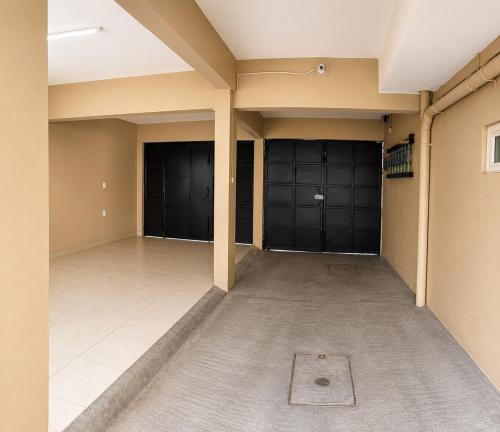 a large empty room with two garage doors at Casa Postal, Loft cerca del Centro, wifi rápido y estacionamiento in Oaxaca City