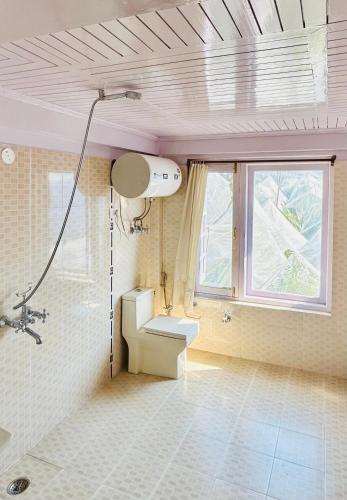 a bathroom with a shower and a sink and a window at The Sayo Ratnari in Bāgi