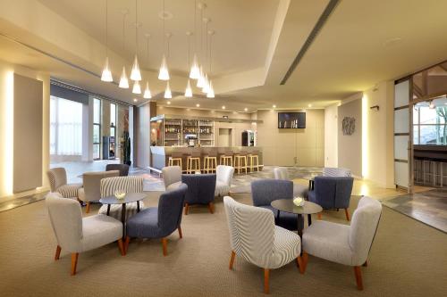 a lobby with tables and chairs and a kitchen at Eurostars Las Salinas in Caleta De Fuste