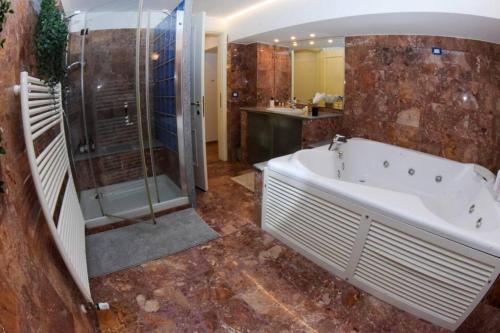 a large bathroom with a tub and a shower at Milan Luxury Loft with Sauna & Jacuzzi in Milan