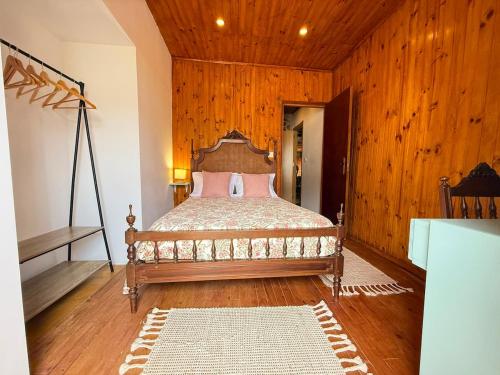 a bedroom with a bed in a room with wooden walls at Casa da Sequeirinha in Barreiros