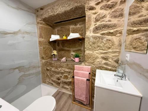 a bathroom with a sink and a stone wall at Casa da Sequeirinha in Barreiros