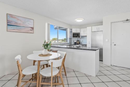 a kitchen and dining room with a table and chairs at Seascape U7 in Golden Beach