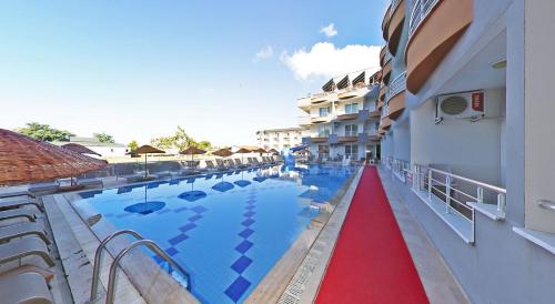 a swimming pool with a red carpet next to a hotel at Sare Hotel in Erdek
