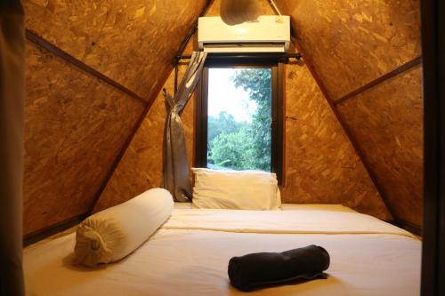 a room with a bed in a small room with a window at Hidden Gem Elephant in Chiang Mai