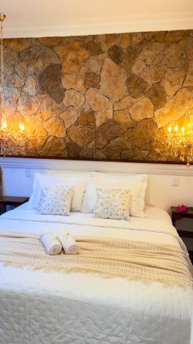 a large bed with two pillows on top of it at Chalé Jardim Itália em Tianguá in Tianguá