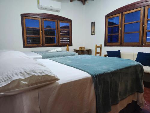 two beds in a room with windows at Casa Legranite Bay in Trujillo